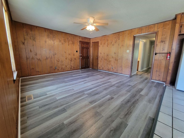 unfurnished room with visible vents, ceiling fan, baseboards, and wood finished floors