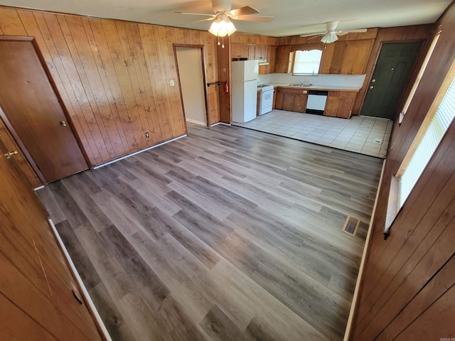 kitchen with ceiling fan, white appliances, light countertops, brown cabinets, and light wood finished floors