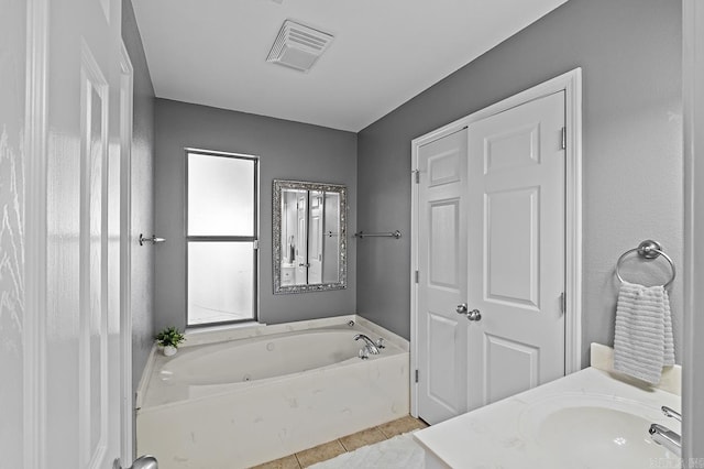 bathroom with visible vents, a sink, a bath, and tile patterned floors