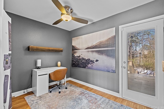 office space featuring wood finished floors, a ceiling fan, and baseboards