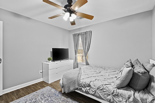 bedroom featuring a ceiling fan, baseboards, visible vents, and wood finished floors