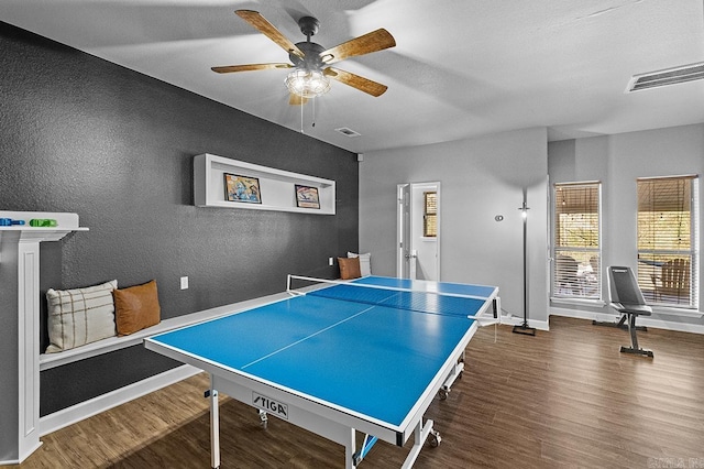 game room with a ceiling fan, visible vents, baseboards, and wood finished floors