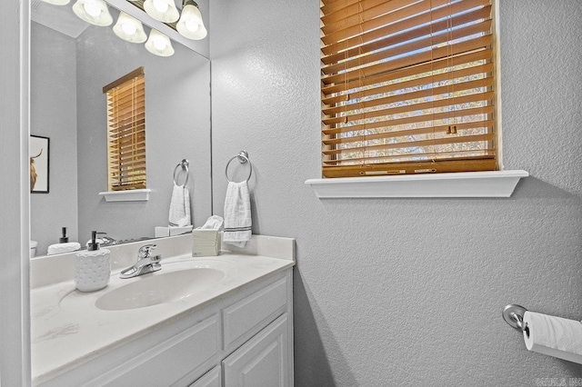 bathroom with a textured wall and vanity