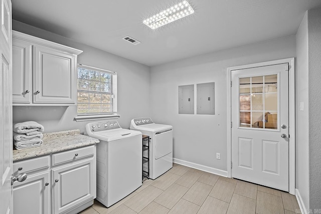 washroom featuring cabinet space, electric panel, visible vents, wood tiled floor, and washing machine and dryer