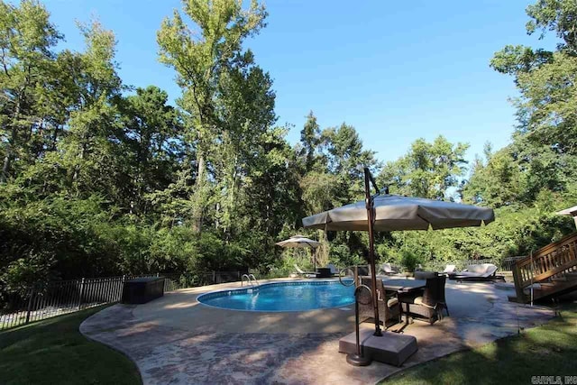 view of swimming pool featuring a patio area, fence, and a fenced in pool