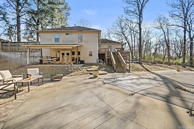 rear view of house featuring stairs, fence, a deck, and a patio