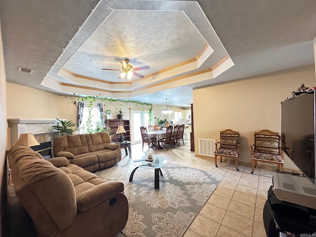 living room featuring ornamental molding, a tray ceiling, a textured ceiling, and visible vents