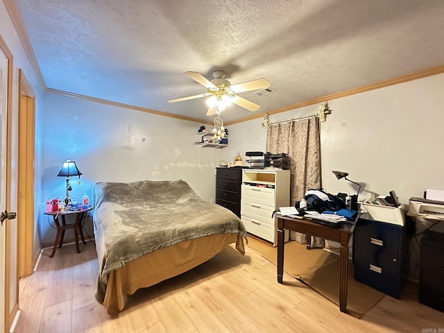 bedroom with light wood finished floors, visible vents, a ceiling fan, a textured ceiling, and crown molding