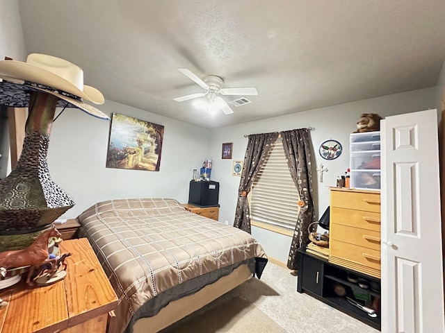 carpeted bedroom with a ceiling fan and visible vents