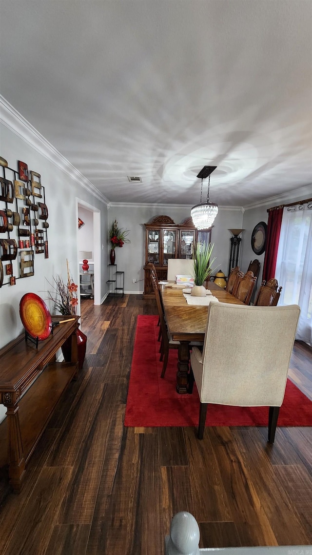 dining space with wood finished floors, visible vents, and crown molding