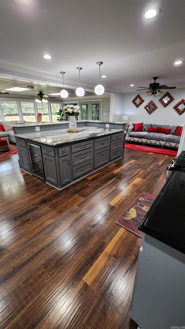 kitchen featuring open floor plan, dark wood-style flooring, a ceiling fan, and gray cabinetry