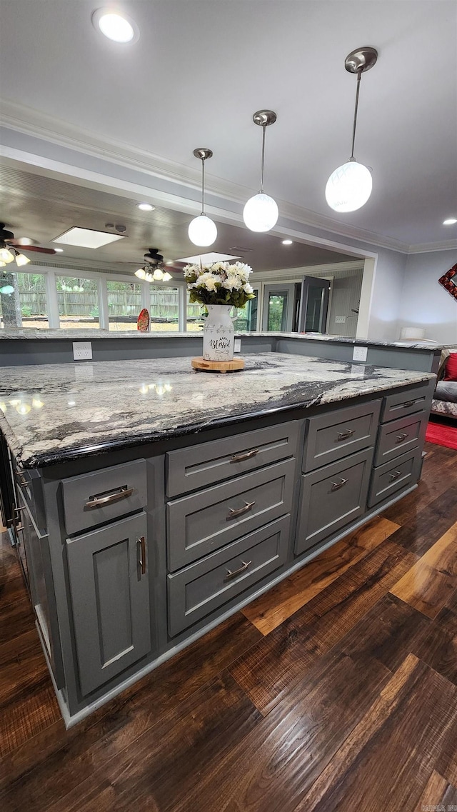 kitchen featuring a ceiling fan, dark wood-type flooring, crown molding, and gray cabinetry