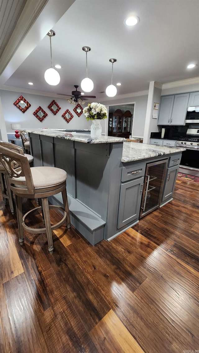 kitchen featuring dark wood-type flooring, ornamental molding, gray cabinetry, and gas range