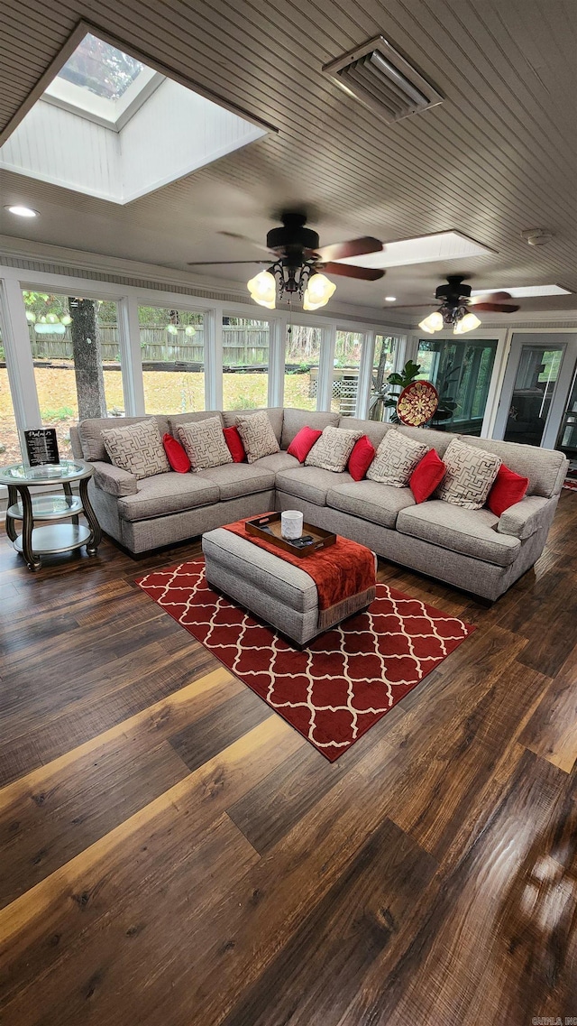 living area featuring a skylight, visible vents, and wood finished floors