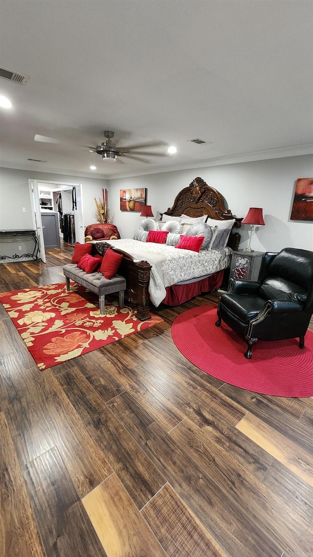 bedroom with ceiling fan, wood finished floors, and visible vents