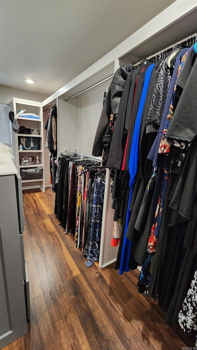 walk in closet with wood finished floors