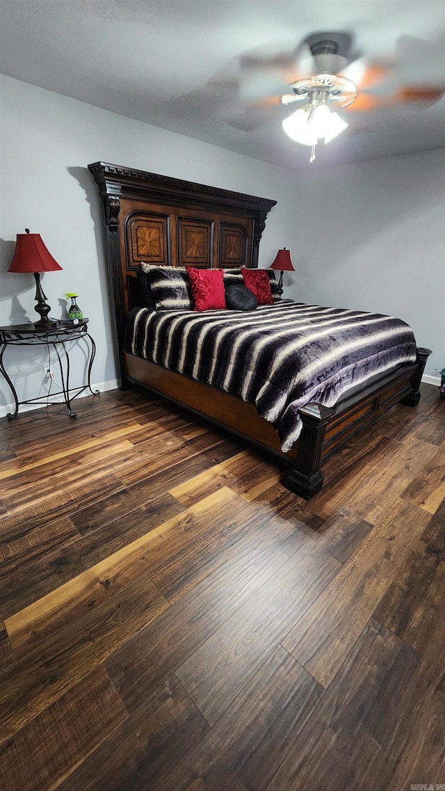 bedroom with wood finished floors, a ceiling fan, and baseboards