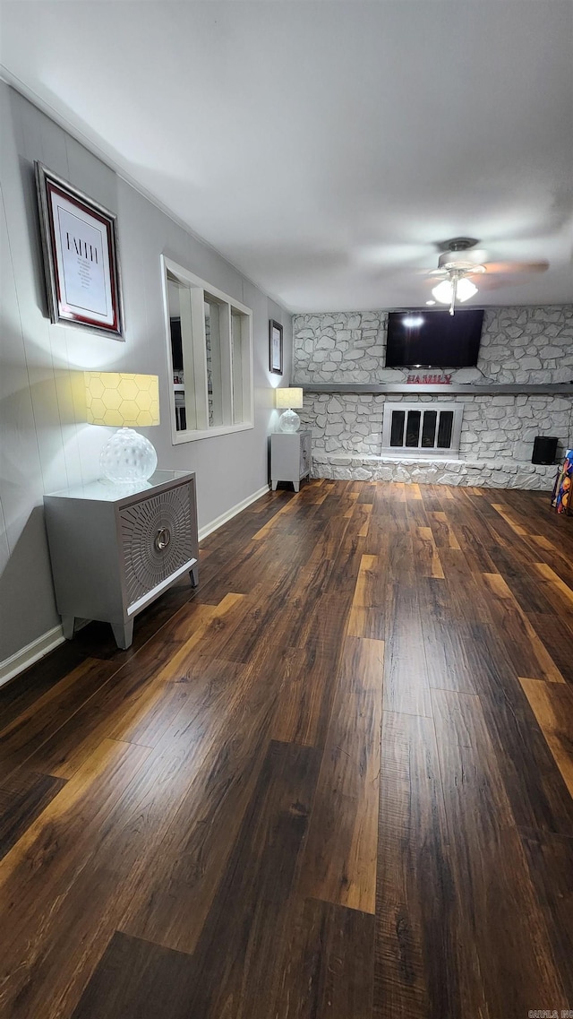 unfurnished living room featuring a ceiling fan, wood-type flooring, and baseboards