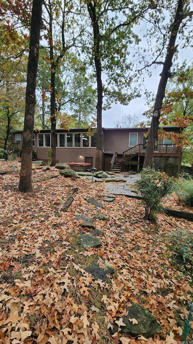 exterior space featuring stairway, a wooden deck, and a sunroom