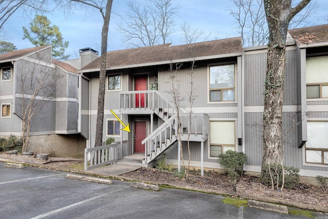 view of building exterior featuring uncovered parking and stairway