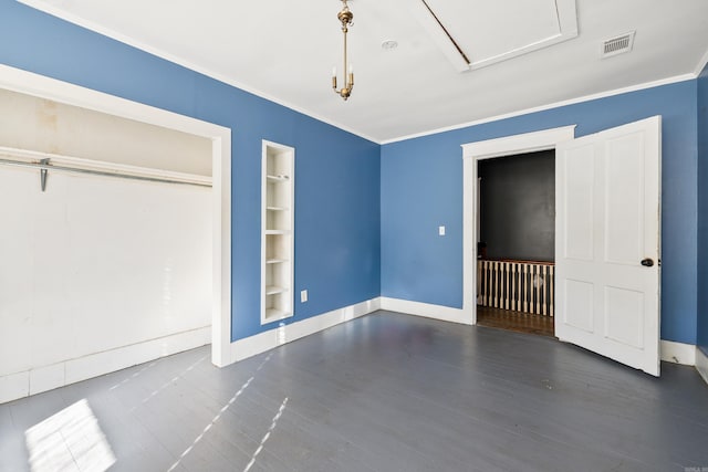 unfurnished bedroom featuring baseboards, wood finished floors, visible vents, and crown molding