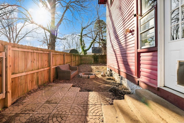 view of yard featuring entry steps, a fenced backyard, and a patio