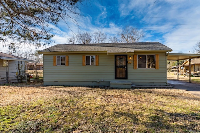 view of front facade with a carport, a front lawn, crawl space, and concrete driveway