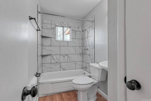 bathroom with toilet, shower / tub combination, baseboards, and wood finished floors