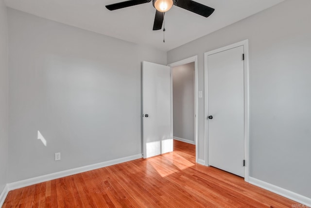 unfurnished bedroom featuring light wood-type flooring, ceiling fan, and baseboards