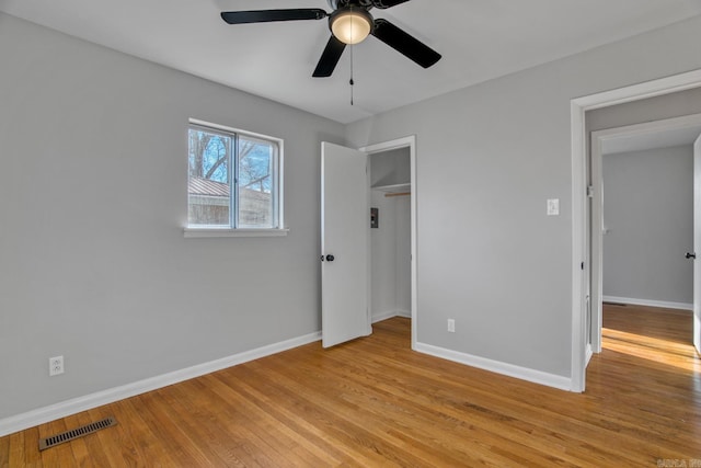 unfurnished bedroom featuring a closet, baseboards, visible vents, and light wood finished floors