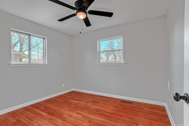 unfurnished room with visible vents, baseboards, and wood finished floors