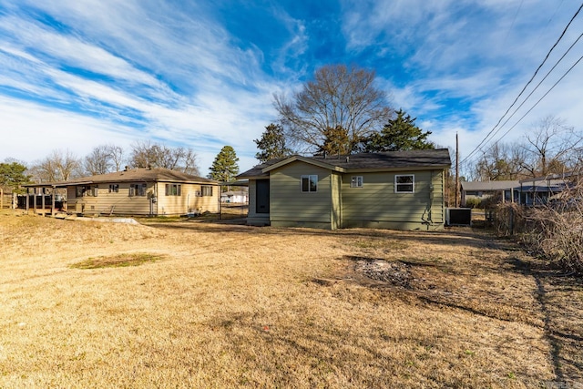 back of house featuring central AC and a yard