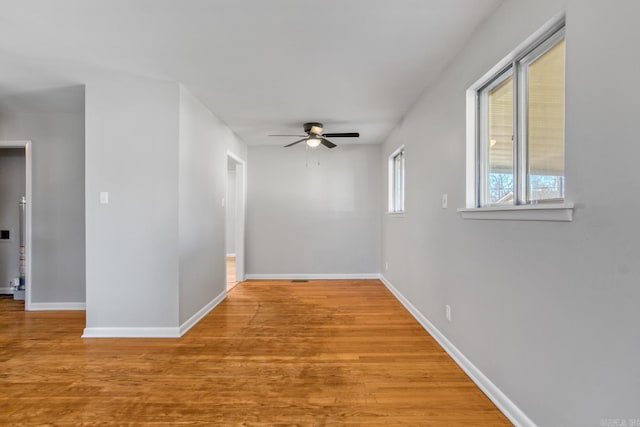 spare room with a ceiling fan, baseboards, and wood finished floors