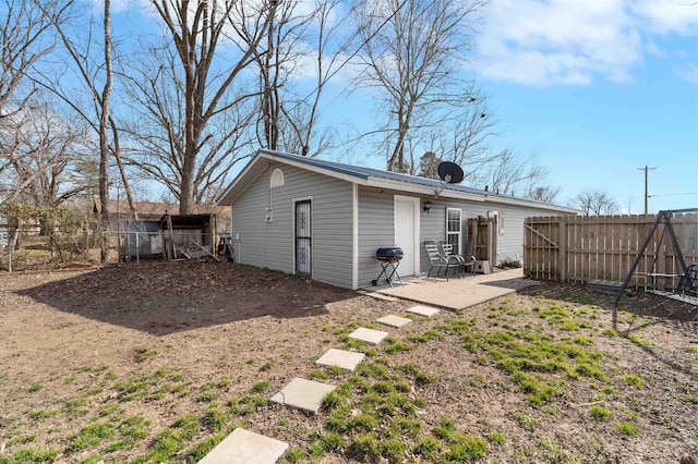 rear view of property featuring a patio and a fenced backyard