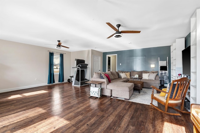 living area featuring a ceiling fan, baseboards, and wood finished floors