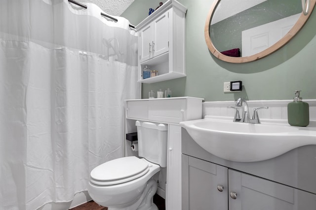 bathroom with toilet, curtained shower, and vanity