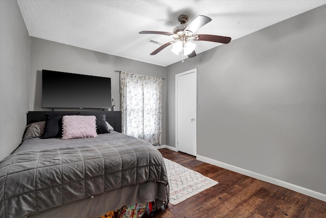 bedroom with ceiling fan, a textured ceiling, baseboards, and wood finished floors