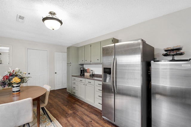 kitchen with visible vents, dark countertops, dark wood-style flooring, a textured ceiling, and stainless steel refrigerator with ice dispenser