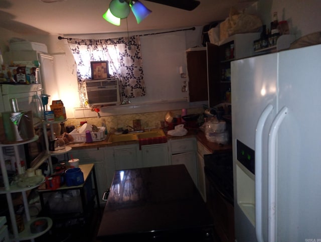 kitchen with white refrigerator with ice dispenser, tasteful backsplash, white cabinets, a sink, and ceiling fan