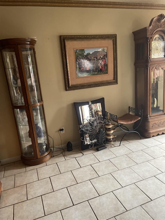 living area featuring ornamental molding, light tile patterned flooring, and baseboards