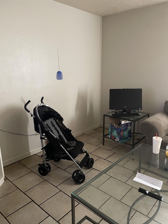 exercise room with baseboards and a textured ceiling