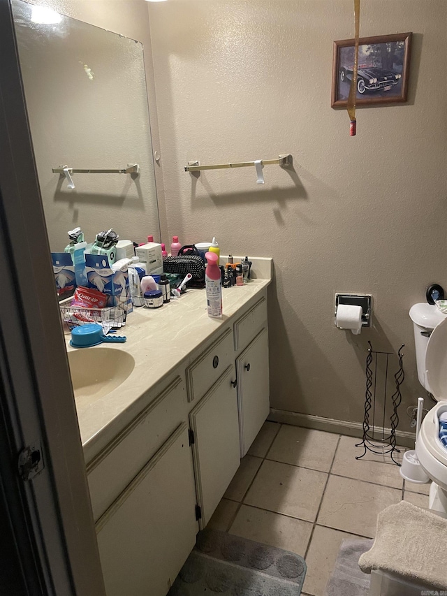 bathroom with baseboards, vanity, toilet, and tile patterned floors