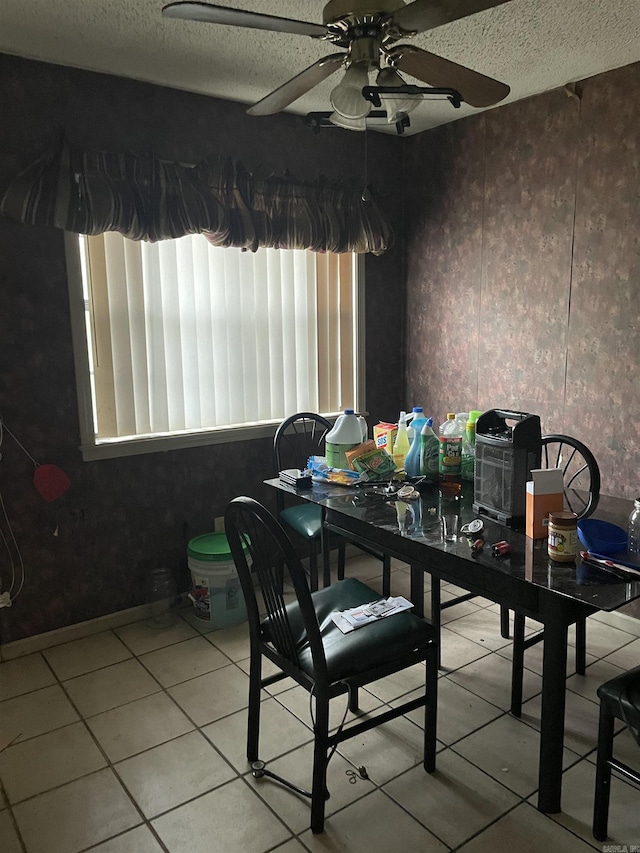 dining area with a textured ceiling, plenty of natural light, a ceiling fan, and tile patterned floors