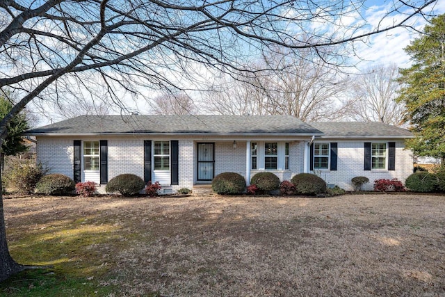 single story home with roof with shingles and brick siding