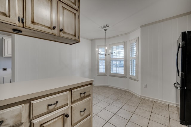 kitchen with light tile patterned floors, visible vents, ornamental molding, freestanding refrigerator, and light countertops