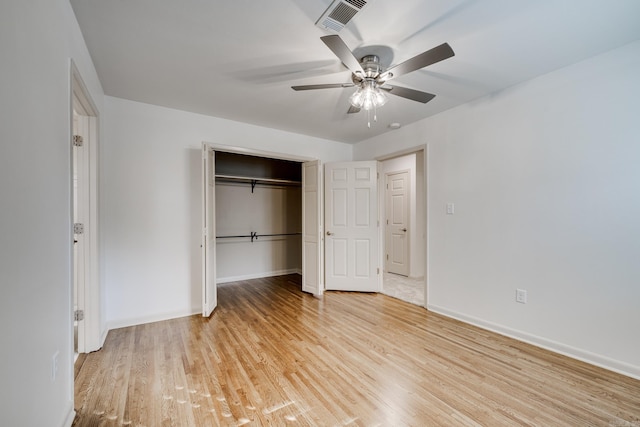 unfurnished bedroom featuring a ceiling fan, baseboards, visible vents, light wood-style floors, and a closet