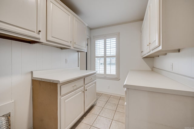 kitchen with light tile patterned floors, baseboards, white cabinets, and light countertops