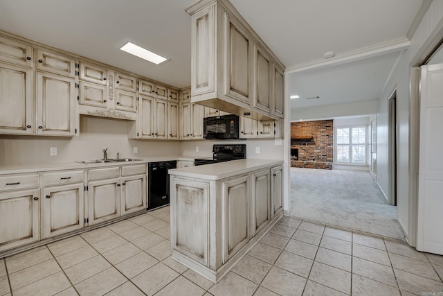 kitchen featuring light countertops, cream cabinets, a sink, and black appliances