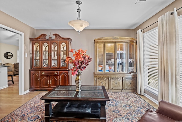 dining area featuring light wood-type flooring, visible vents, and baseboards