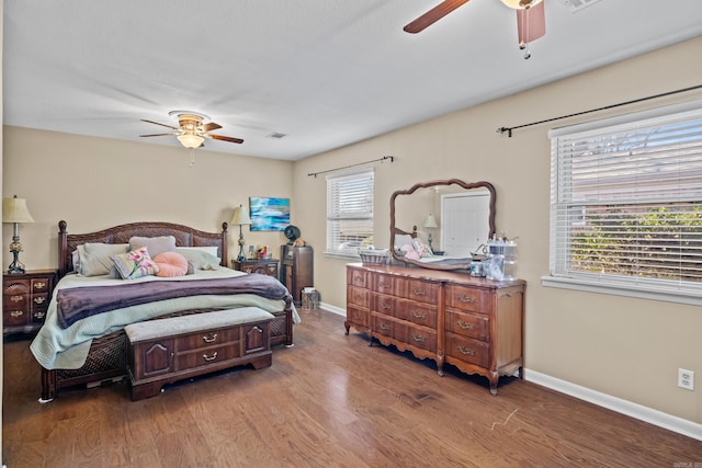 bedroom with ceiling fan, baseboards, and wood finished floors